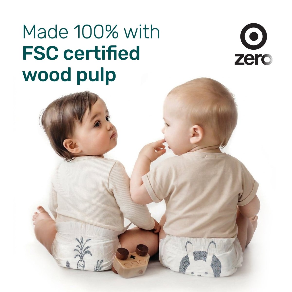 Two babies sitting back to back in Parasol diapers with carrot and bunny prints, with the text “Made 100% with FSC certified wood pulp”