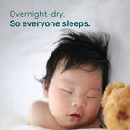 Sleeping baby with dark hair next to a teddy bear, with the text “Overnight-dry. So everyone sleeps.”